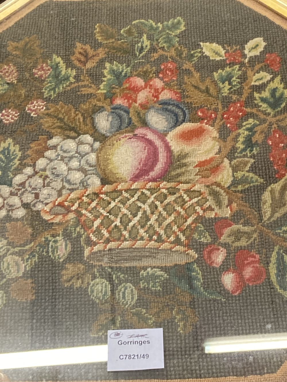 An grois point tapestry panel, inset in the top of a hexagonal mahogany table, width 54cm, depth 48cm, height 48cm
